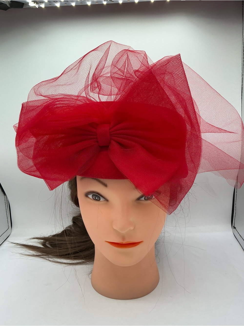 Vintage red structured fascinator hat with a tulle net veil and a mesh bow